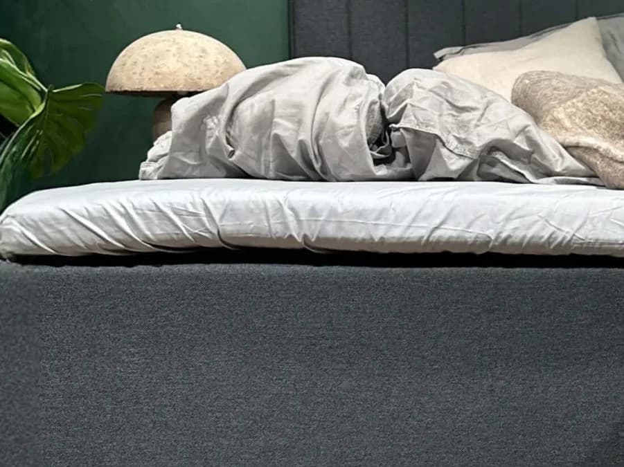 Primo piano del lenzuolo FamBed teso sul topper di un letto familiare